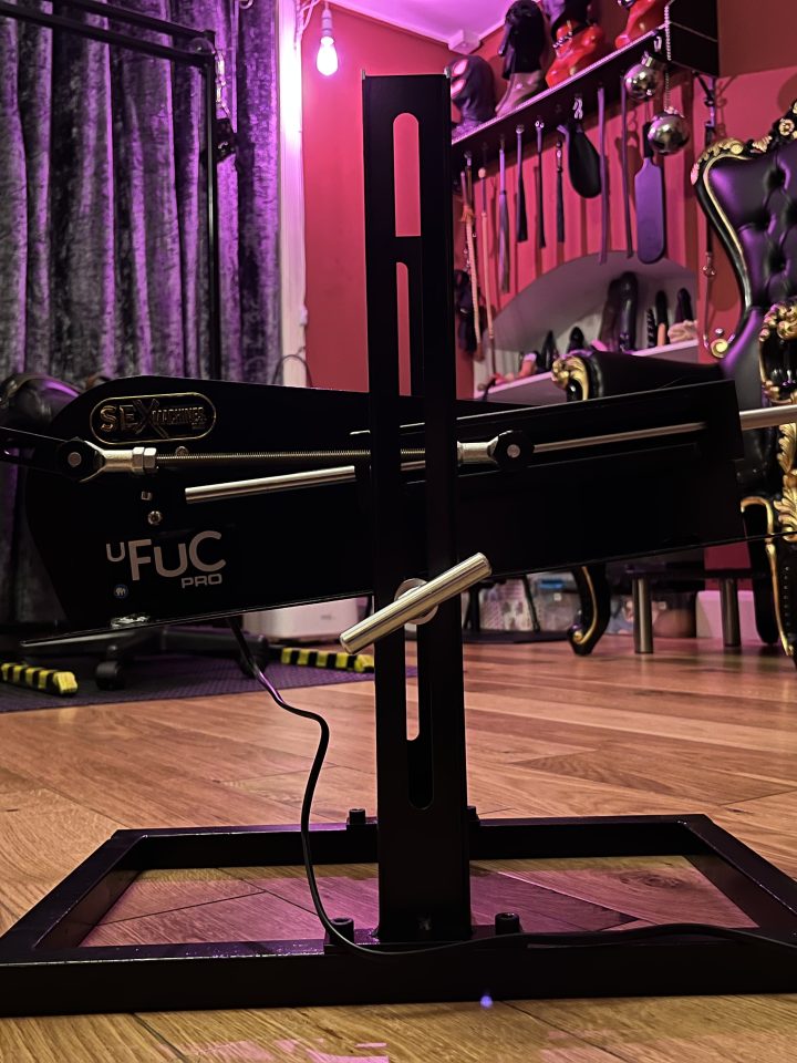 Sex machine and throne in the purple-lit dungeon room