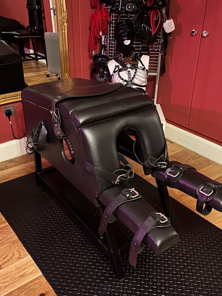 Side view of the leather spanking bench with cuffs