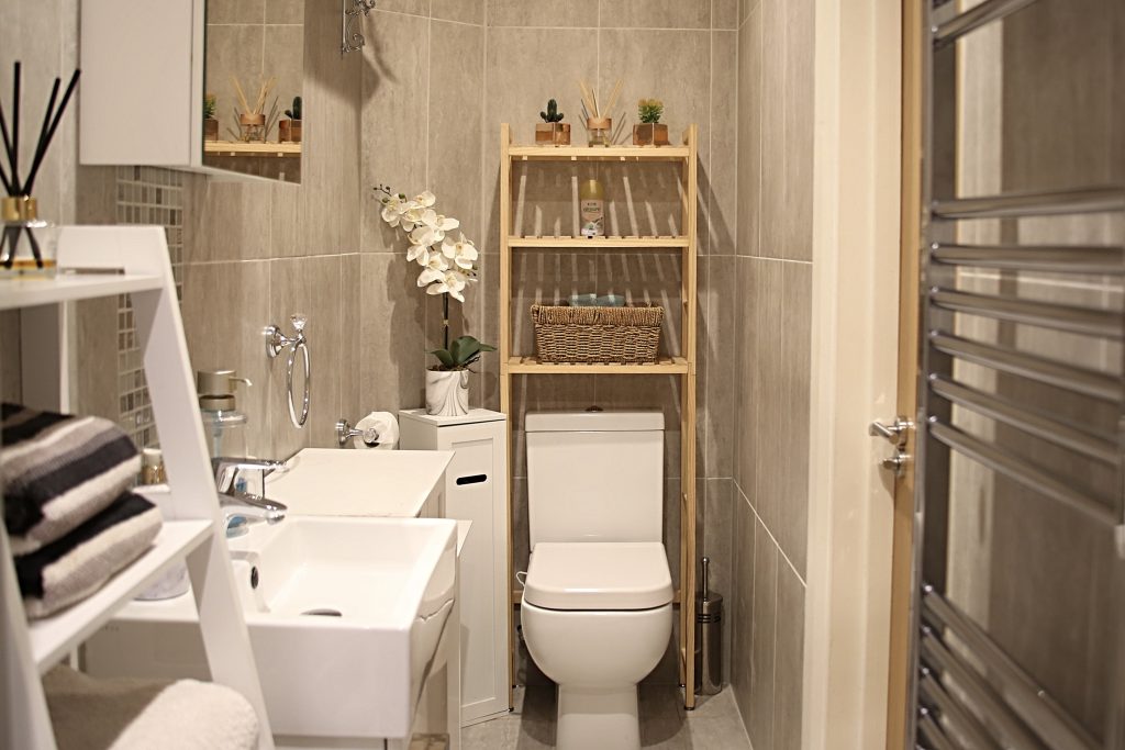 Bathroom with white basin unit, towels and heated towel rail