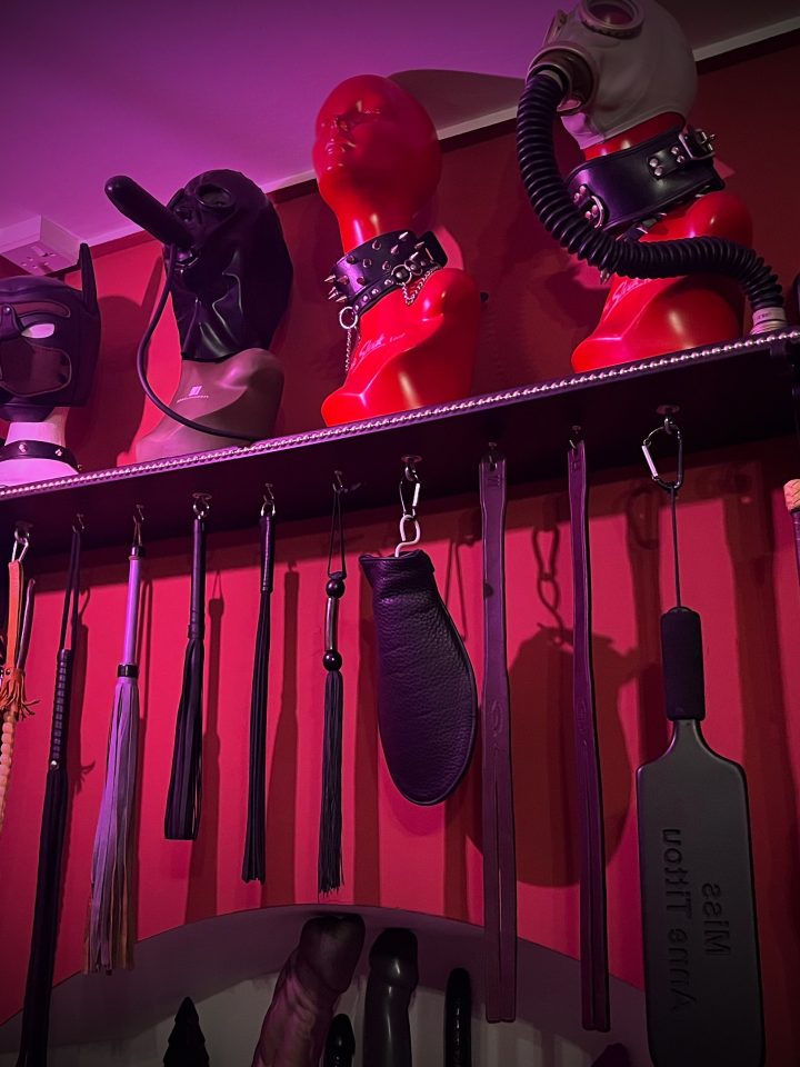 Rack of canes, crops, paddles and hoods for impact play