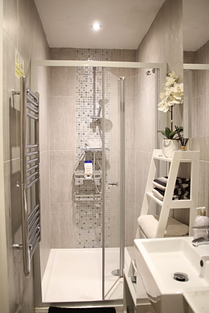 Walk-in shower with glass screen and heated towel rail in the private bathroom