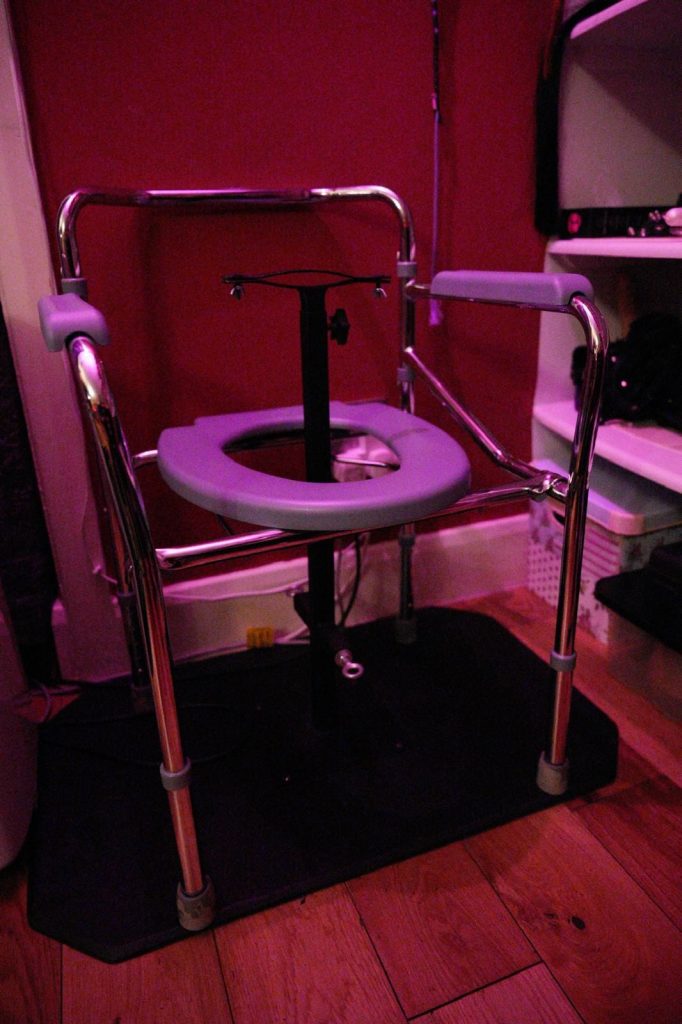 Steel-framed queening chair with padded seat on a rubber mat