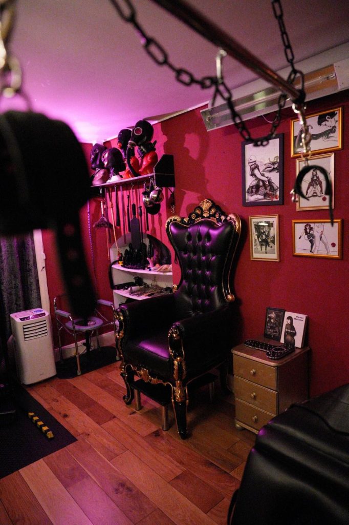 Throne under a chain suspension point with framed art on the wall
