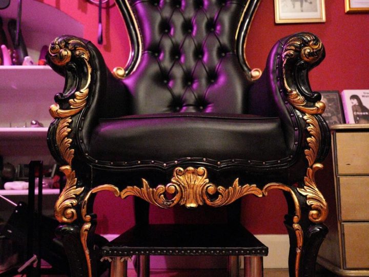 Ornate black leather throne with gold carvings in the Bayswater dungeon
