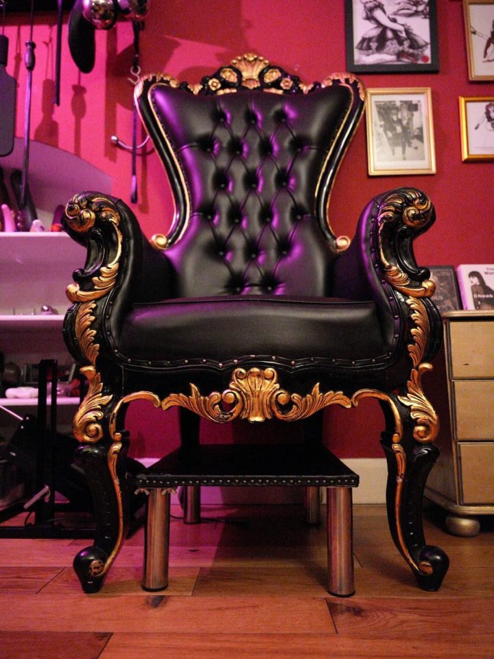 Ornate black leather throne with gold carvings in the Bayswater dungeon