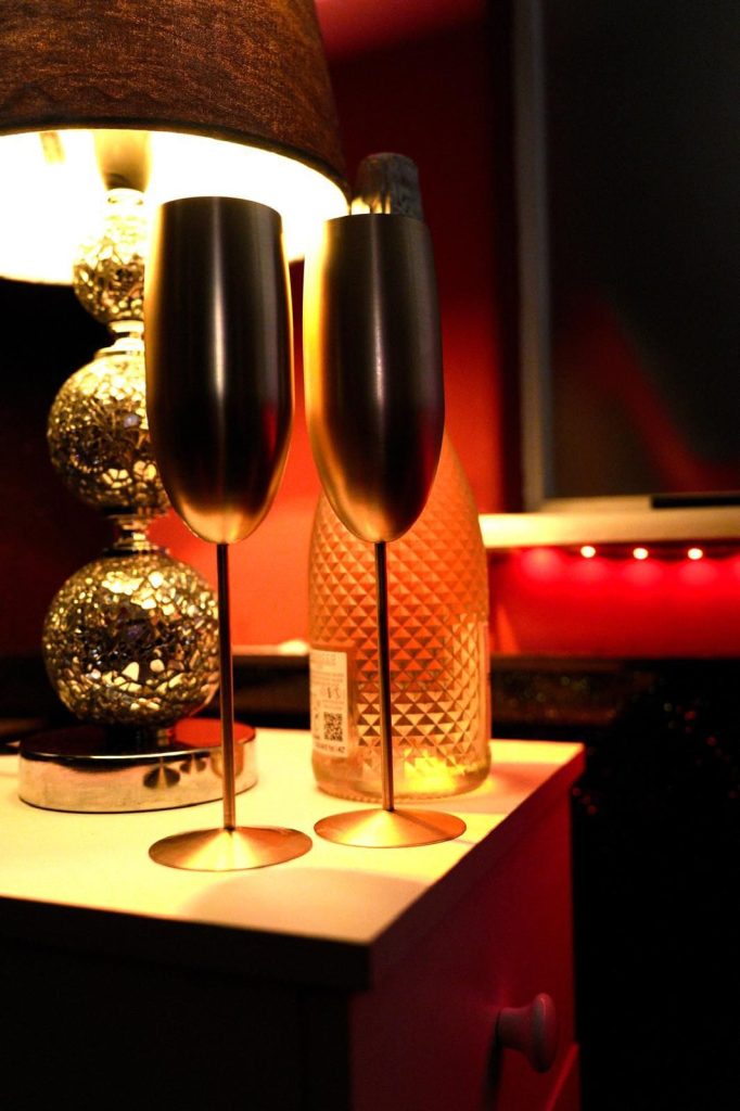 Gold champagne flutes under a lamp in the red room